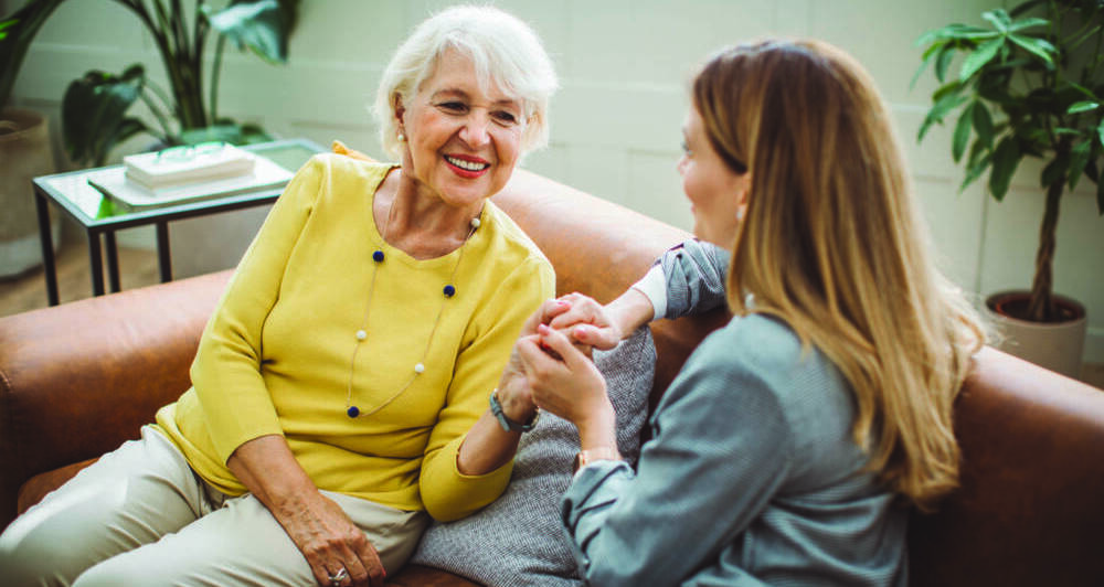 Senior woman talking with her daughter at home.