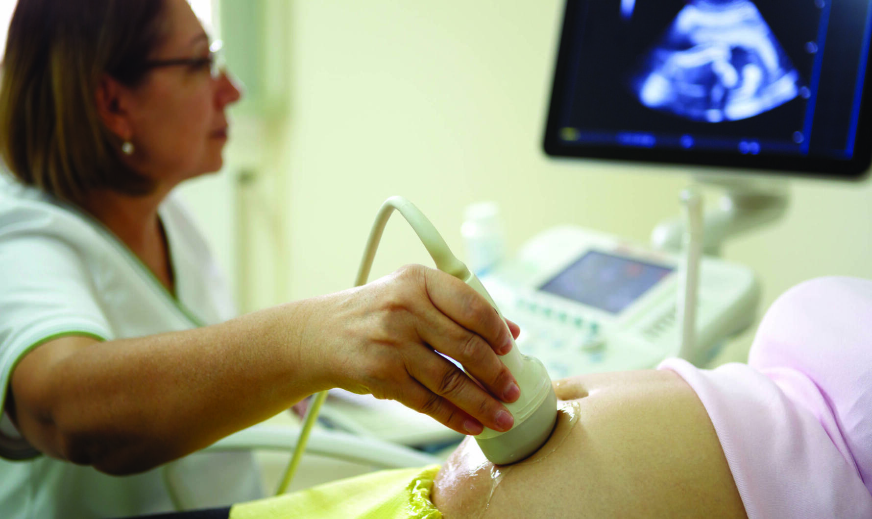 Doctor performing ultrasound on a pregnant woman